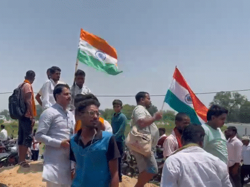 हाथ में तिरंगा लेकर लोग महापंचायत में पहुंचे हैं।