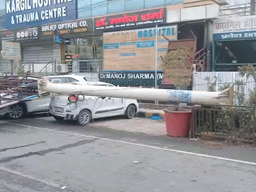 यूपी के आगरा में तेज आंधी के कारण होर्डिंग पोल सड़क पर खड़े वाहनों पर गिर गया।