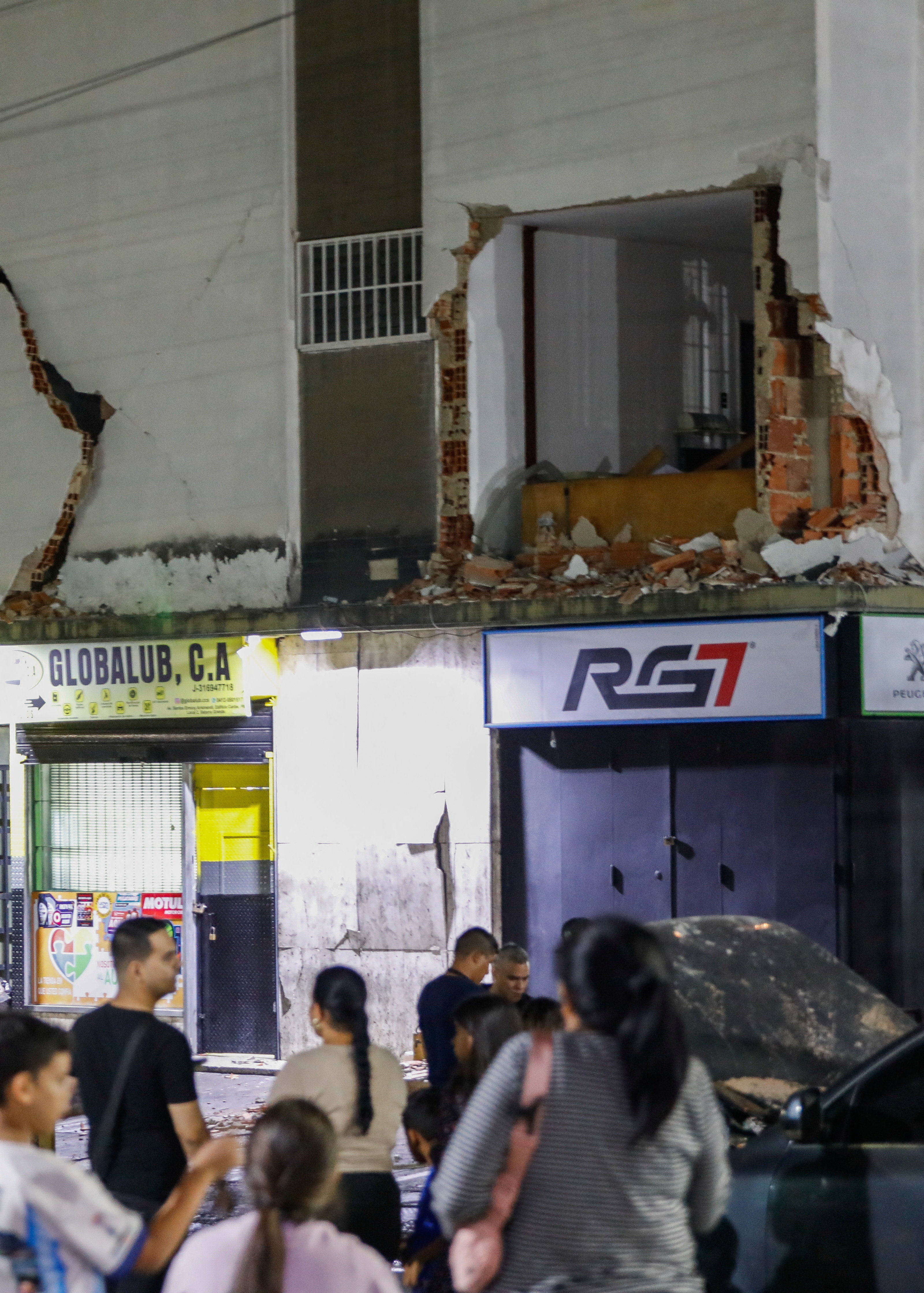 कराकस में भूकंप के बाद डर के मारे लोग अपने घरों से बाहर निकल आए हैं और भारी नुकसान झेल चुकी एक इमारत के पास खुले मैदान में इकट्ठा हो गए।