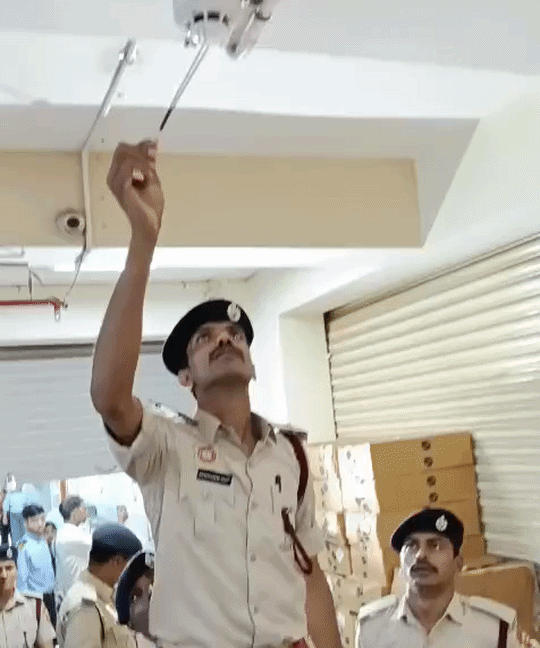 धुआं से कोचिंग सेंटर में लगे स्मोक डिटेक्टर की जांच करते अग्निशमन विभाग के अधिकारी।