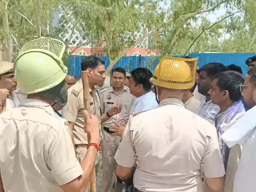 कांग्रेस के शहरी जिला अध्यक्ष प्रदीप गुलिया से बात करते पुलिस अधिकारी।