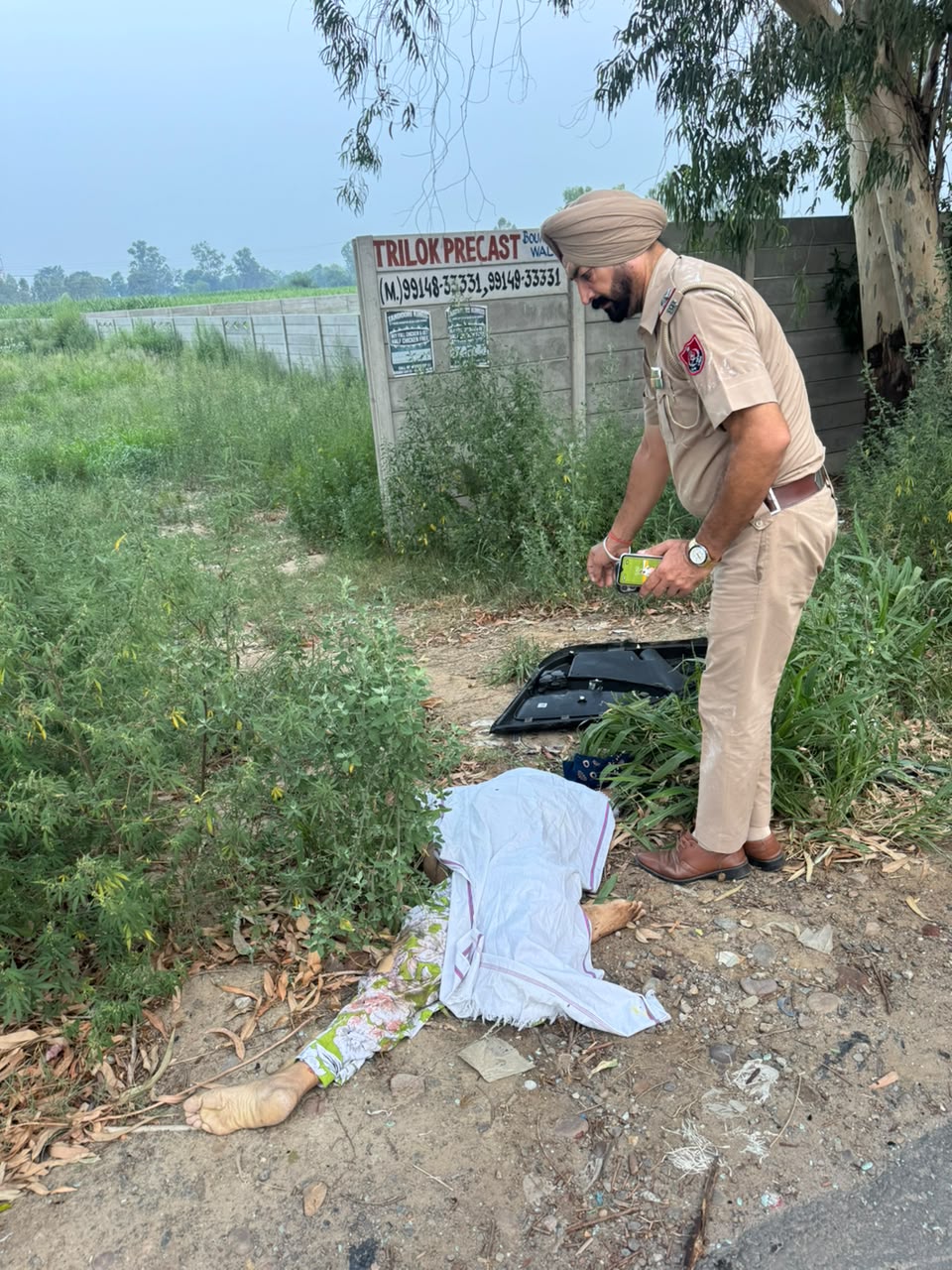 सड़क किनारे पड़ी महिला की लाश, पुलिस जांच करती हुई।