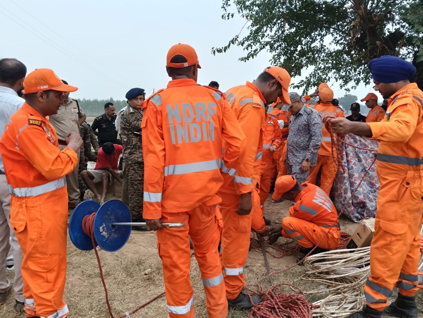 NDRF की टीम स्पेशल तरह की कुंडी बनाते हुए, ताकि यह किसी तरह बच्चे के कपड़े में फंसे और उसे बाहर खींचा जा सके।