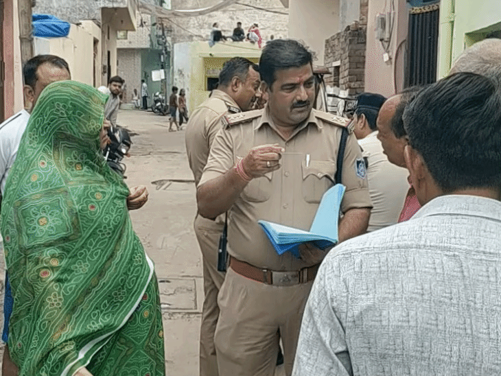 घटनास्थल पर पहुंचकर घर के बाहर जांच करते पुलिस अधिकारी।