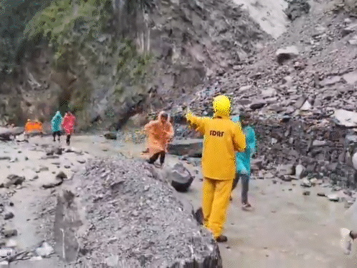 उत्तराखंड में केदारनाथ यात्रा पर आए हुए लोगों को सुरक्षित रास्ता पार कराती एसडीआरएफ की टीम।