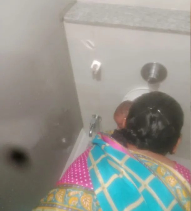 फोटो में एक देखभालकर्ता शौचालय में बैठे बच्चे के चेहरे पर जेट से पानी डाल रहा है। (फोटो सोशल मीडिया पर वायरल है)