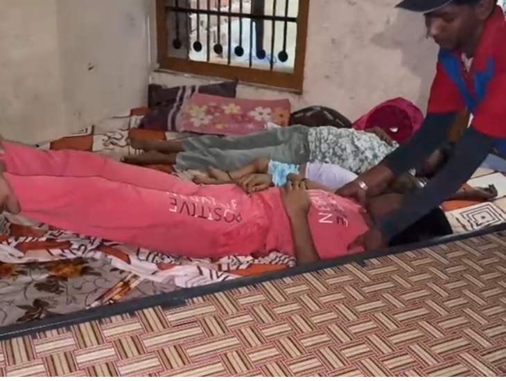 कमर से बच्चों के शवों को ले जाते हुए।