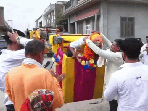 महाबीर यांना नोटांची माळ घालताना त्यांचे शेजारी.