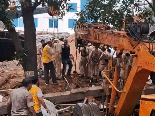 बिल्डिंग के अंदर फंसे लोगों को बाहर निकालने के लिए रास्ता बनाते हुए रेस्क्यू टीम।