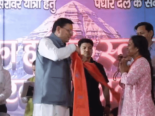 सीएम धामी ने श्रद्धालु को शिव पटका और रुद्राक्ष की माला पहनाई।
