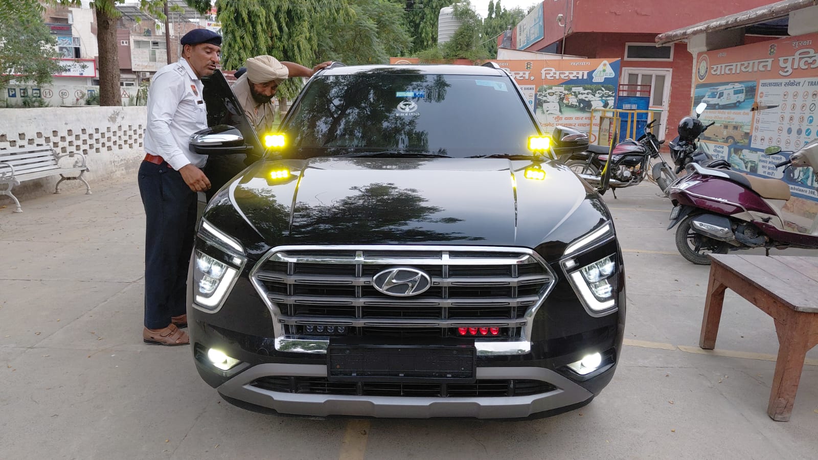 थाने में खड़ी गाड़ी में लगी रंग-बिरंगी लाइटें और अंदर से चेक करते हुए पुलिस