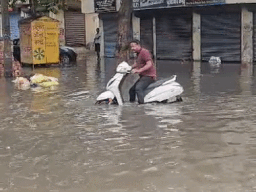 हरियाणा के यमुनानगर में सड़क पर अधिक पानी होने से स्कूटर बंद हो गई।