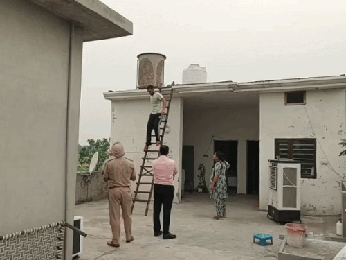 कड़ी मशक्कत के बाद युवक को छत से उतवाते हुए पुलिस।