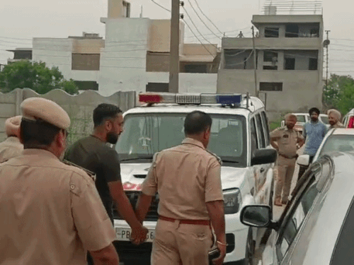 युवक को हिरासत में लेकर जाते हुए पुलिसकर्मी