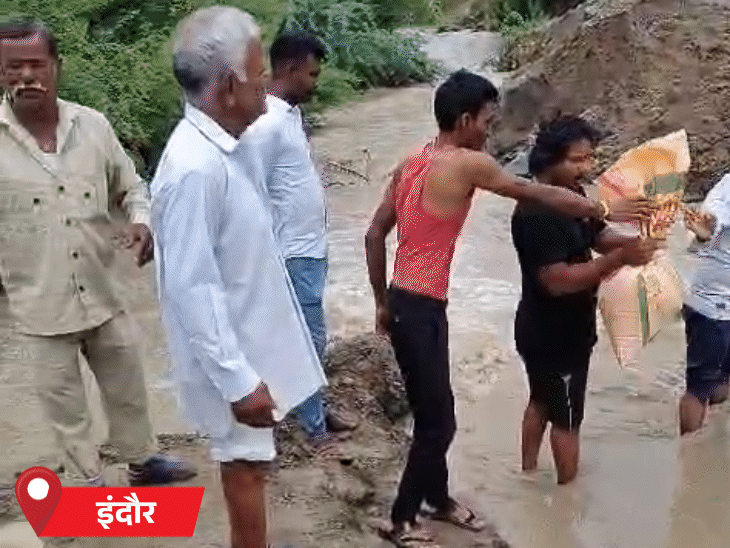 इंदौर से 30 किमी दूर जेतकारण गांव में सड़क धंस गई। ग्रामीणों ने मानव शृंखला बनाकर बच्चों को उफनते नाले से सुरक्षित पार कराया।