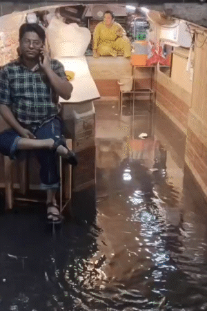 हापुड़ में बारिश का पानी दुकानों में घुस गया। कारोबारी स्टूल पर बैठकर खुद को बचाते दिखे।