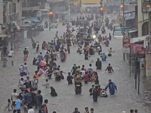 सूरत के होली बंगला इलाके में बारिश के बार सड़कों पर कमर तक पानी भर गया।