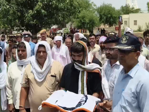 तिरंगा सौंपने के दौरान पिता भागीरथ (गुलाबी टी शर्ट) भावुक हो गए। वहीं उनके पास चचेरा भाई तिरंगा लिए चलता रहा।