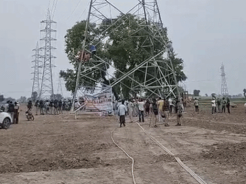 सिरसा में बिजली टावर पर चढ़ते किसान नेता।