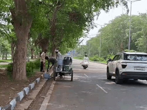 सड़कों पर पेंट करते कर्मचारी।