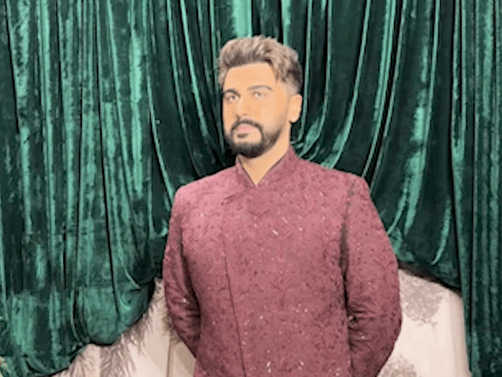 Arjun Kapoor is wearing a wine-colored suit.
