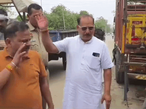 नगर पालिका की अतिक्रमण हटाने की कार्रवाई के दौरान सेनेटरी इंस्पेक्टर फूल कुमार और भाजपा के पूर्व मंडल अध्यक्ष पवन सैनी बहस करते हुए। - Dainik Bhaskar