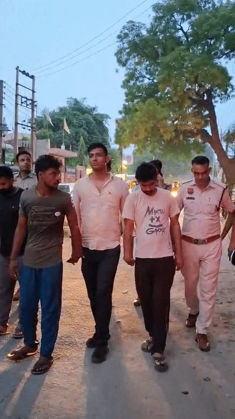 रेवाड़ी में आरोपियों के साथ सड़क पर पैदल चलती पुलिस।