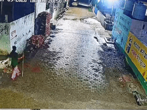 पुजारी को पीटने के लिए लाठी लेकर जाती आरोपी पंकज की पत्नी।