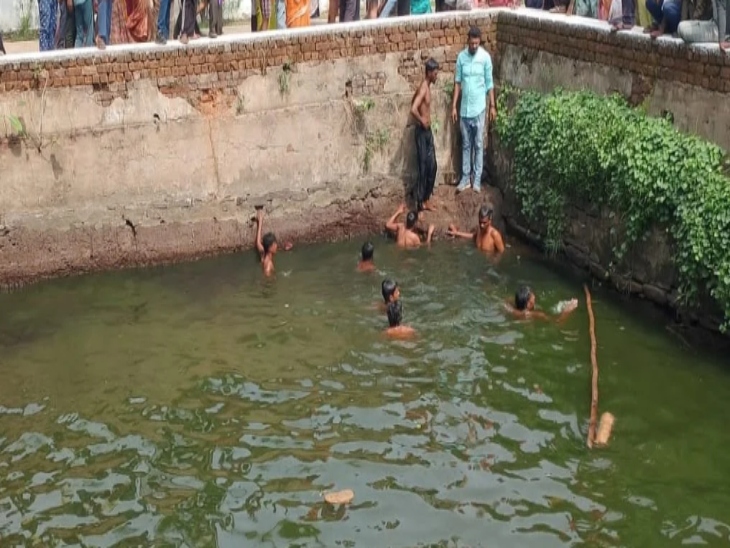 बच्चों के शव को तलाशते हुए गोताखोर और ग्रामीण।