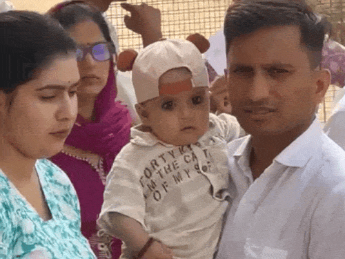 एक महिला अभ्यर्थी ने परीक्षा में जाने से पहले अपने बच्चे को परिजन को दिया।