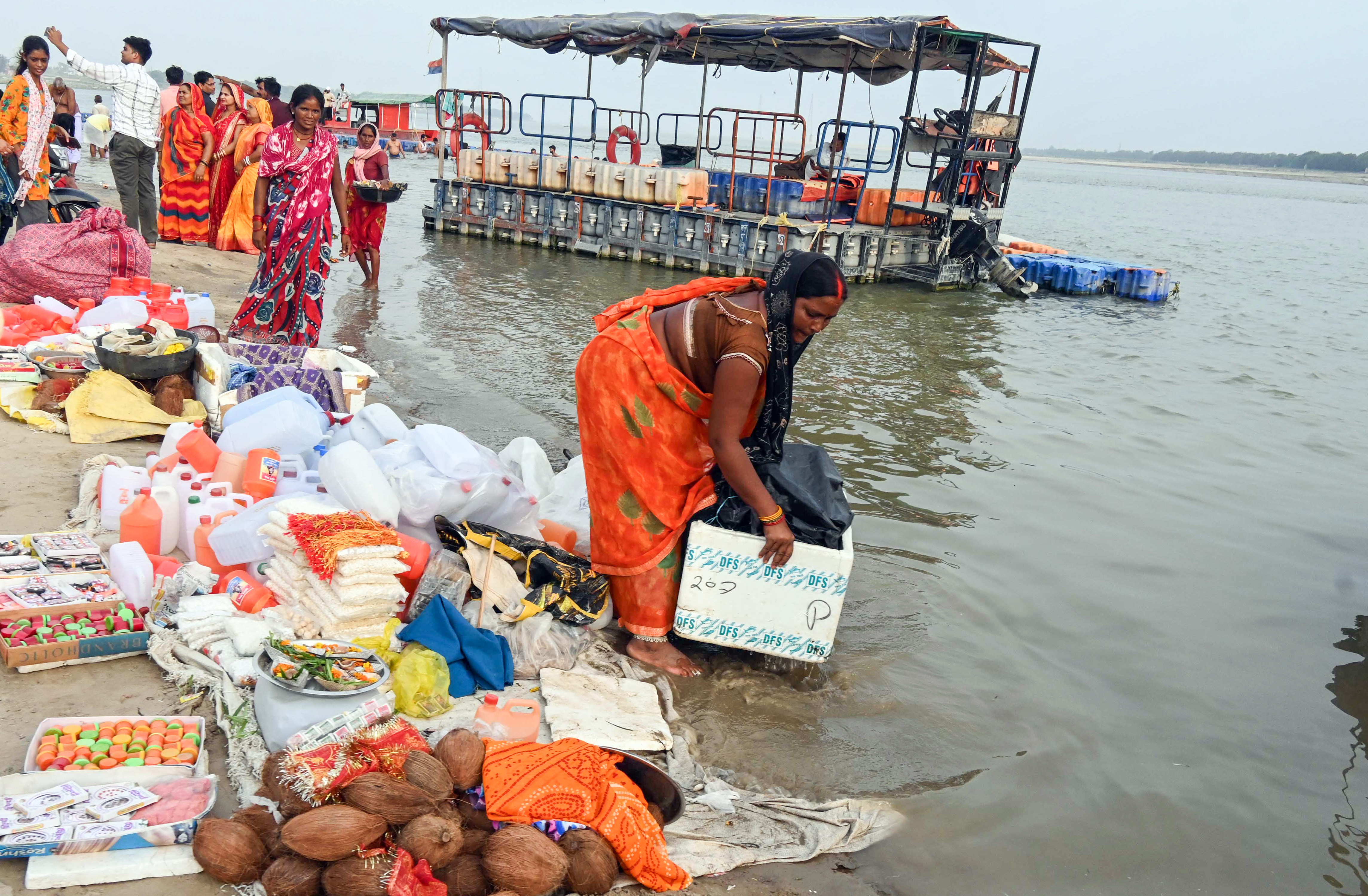 उत्तर प्रदेश के प्रयागराज में गंगा में पानी बढ़ने लगा है। संगम पर दुकान लगाए बैठी महिला को जल्दबाजी में सामान हटाना पड़ा।