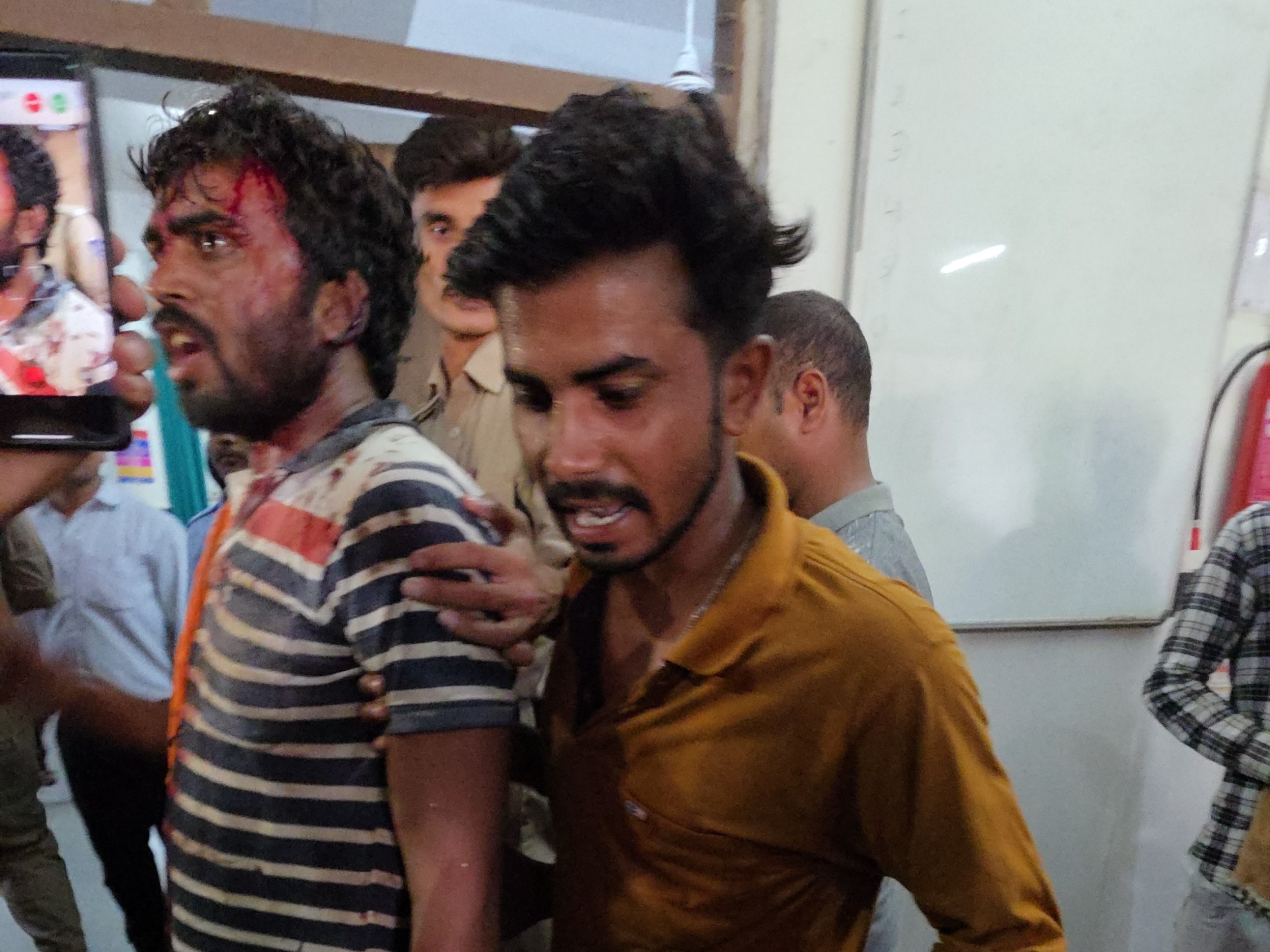 घायल को (टी-शर्ट में) परिजन जिला अस्पताल लेकर आए। उनकी हालत गंभीर बताई जा रही है