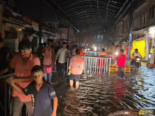 अयोध्या में तेज बारिश से भक्ति पथ मार्ग में भरा पानी, घुटनों तक पानी में उतरकर मंदिर पहुंचे लोग।