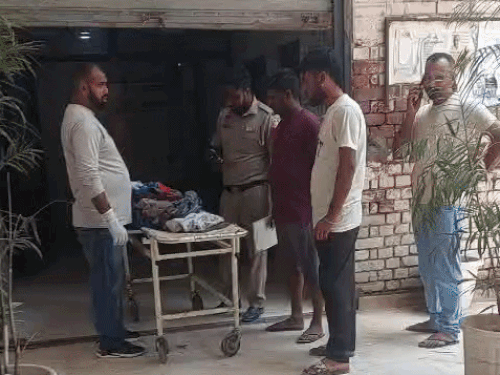 समरदीप का शव मोर्चरी में रखवाते पुलिसकर्मी।
