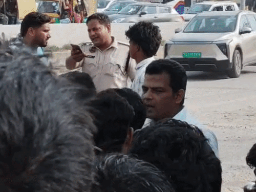 Police explaining to the riders standing in front of the dumper on the highway.
