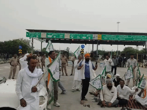 थाना टोल प्लाजा पर दरी बिछाकर बैठे किसान