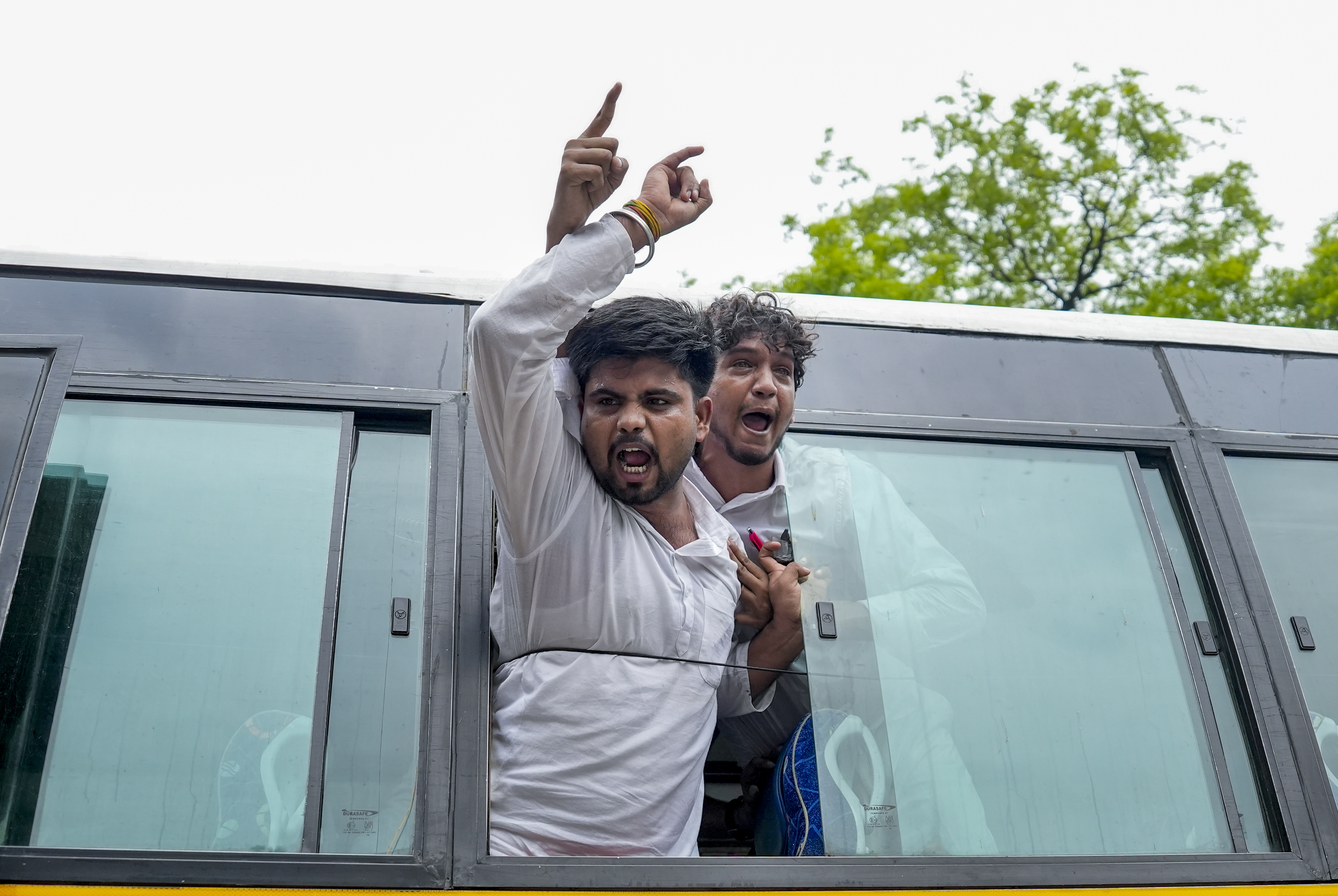 हिरासत में लिए प्रदर्शनकारियों को बस में भरा गया।