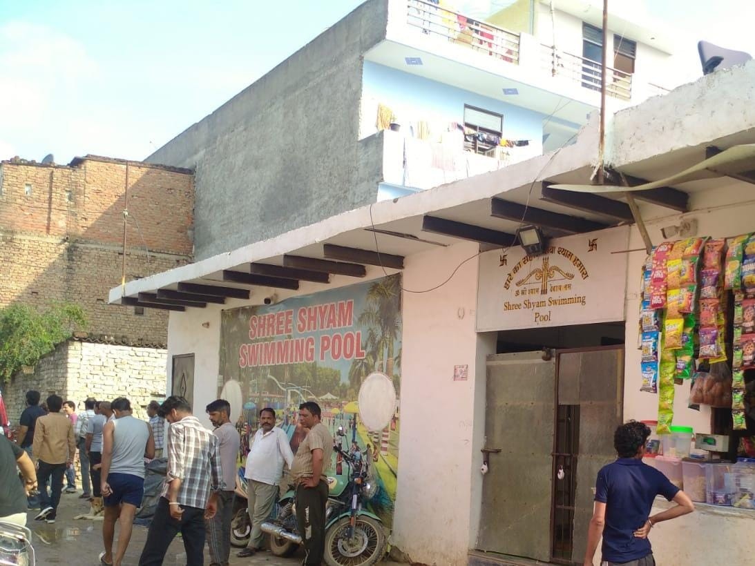 स्विमिंग पूल के सील होने के बाद जाते लोग।