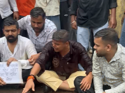 रायपुर में बारिश के बीच धरने पर बैठे NSUI कार्यकर्ता।