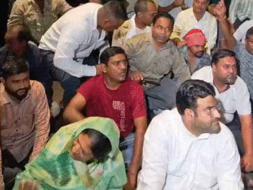 देर रात बारिश के बीच कांग्रेस कार्यकर्ता लोकभवन के बाहर बैठे रहे।