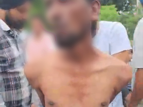 चोर से पूछताछ करते हुए लोग।