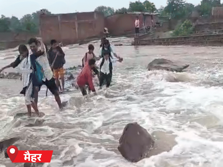 मध्यप्रदेश में मैहर जिले के सोनवारी में बच्चे उफनते नाले को पार कर स्कूल जाते हुए।