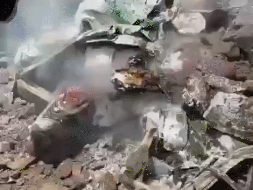 लैंडस्लाइड के बाद गाड़ी में लगी आग को बुझाते हुए लोग।
