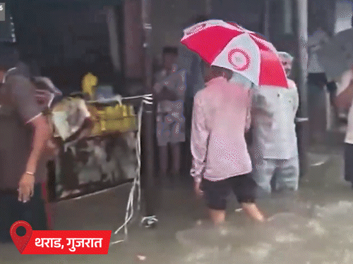 शहर का बड़ा हिस्सा पानी में डूब गया है। लोग पानी से होकर दुकानों से जरूरत का सामान लेने जा रहे हैं।