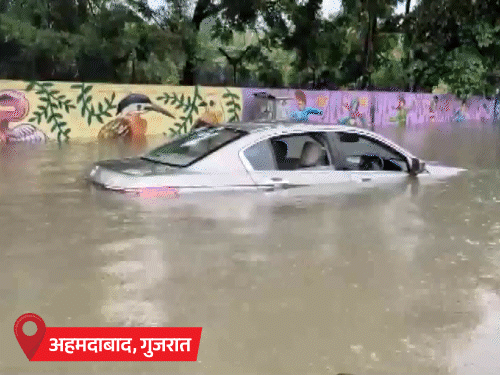 कार पानी में डूब गई। सड़कों पर कमर तक पानी भरा है।