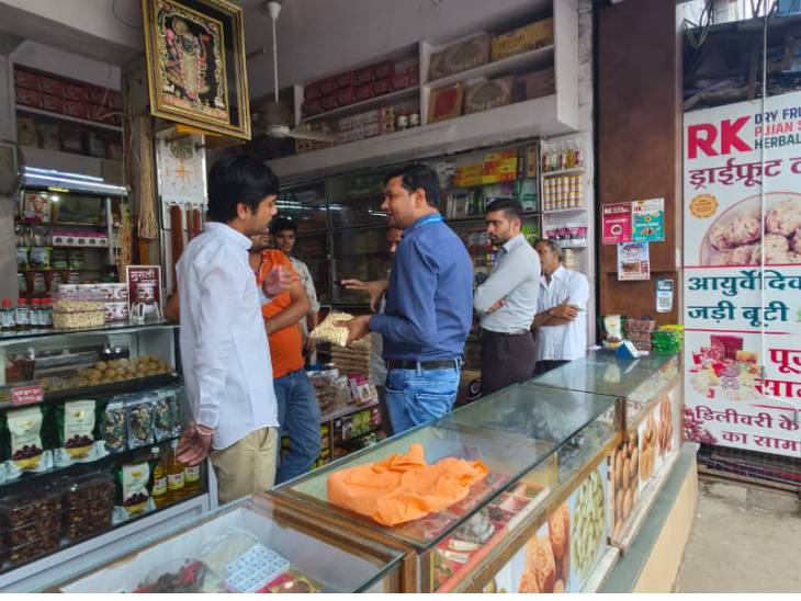 दुकान का निरीक्षण करते खाद्य विभाग के अधिकारी।