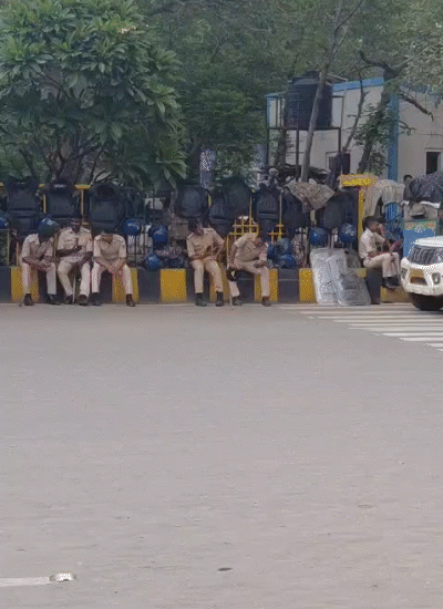 बिस्कोमान के सामने डिवाइडर पर हेलमेट, डंडा लिए बैठे पुलिस कर्मी।