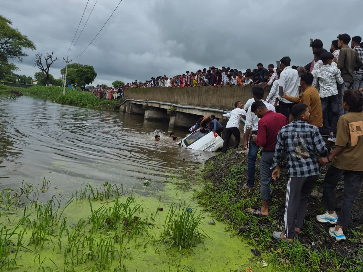 स्थानीय लोग कार और लोगों को बाहर निकालने में मदद कर रहे हैं