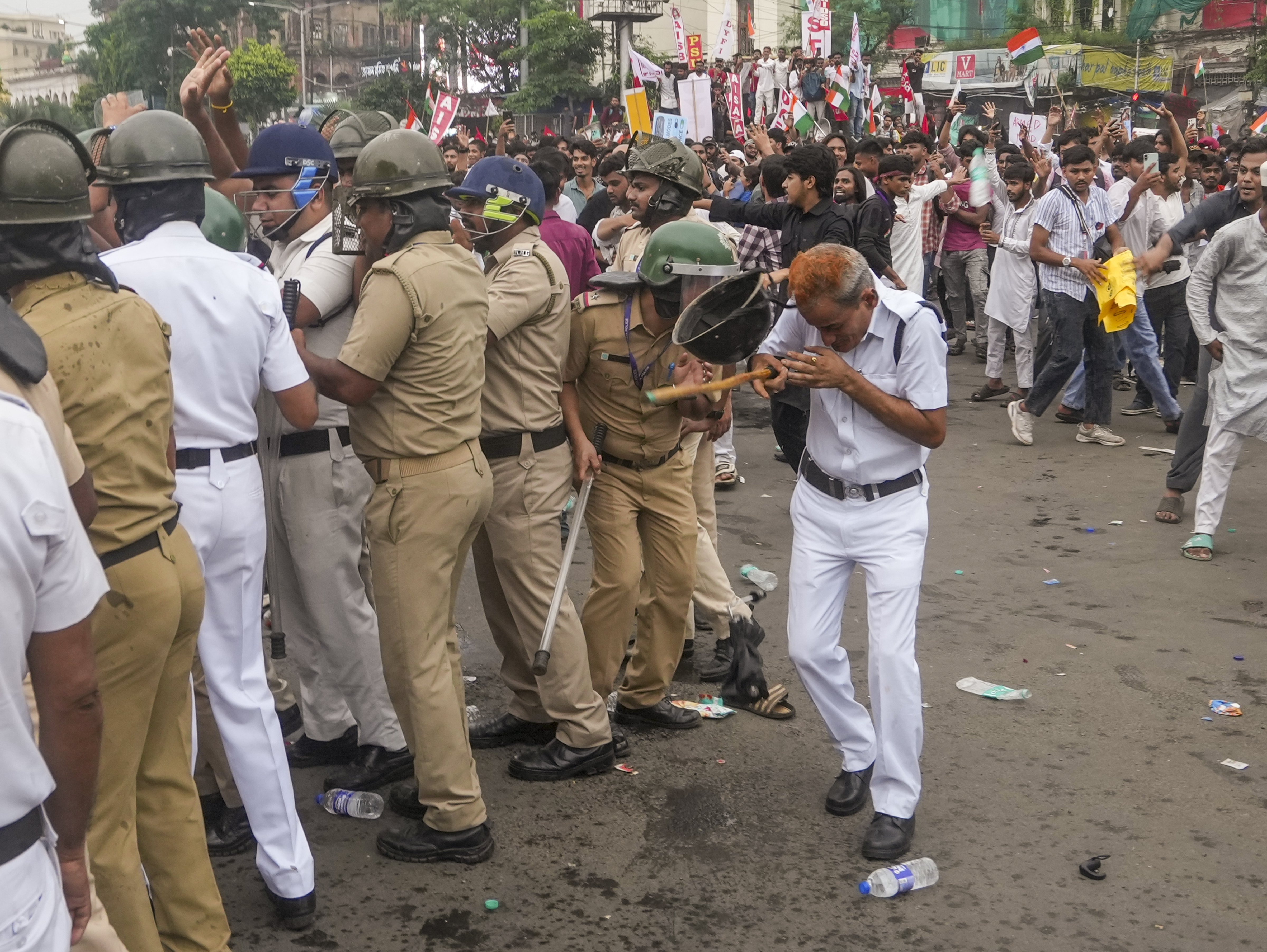 कोलकाता में विरोध प्रदर्शन के दौरान पुलिस पर बॉटल, जूते-चप्पल फेंके। इसी बीच बंगाल पुलिस के अधिकारी के सिर पर लगा हेलमेट निकल कर गिरा।