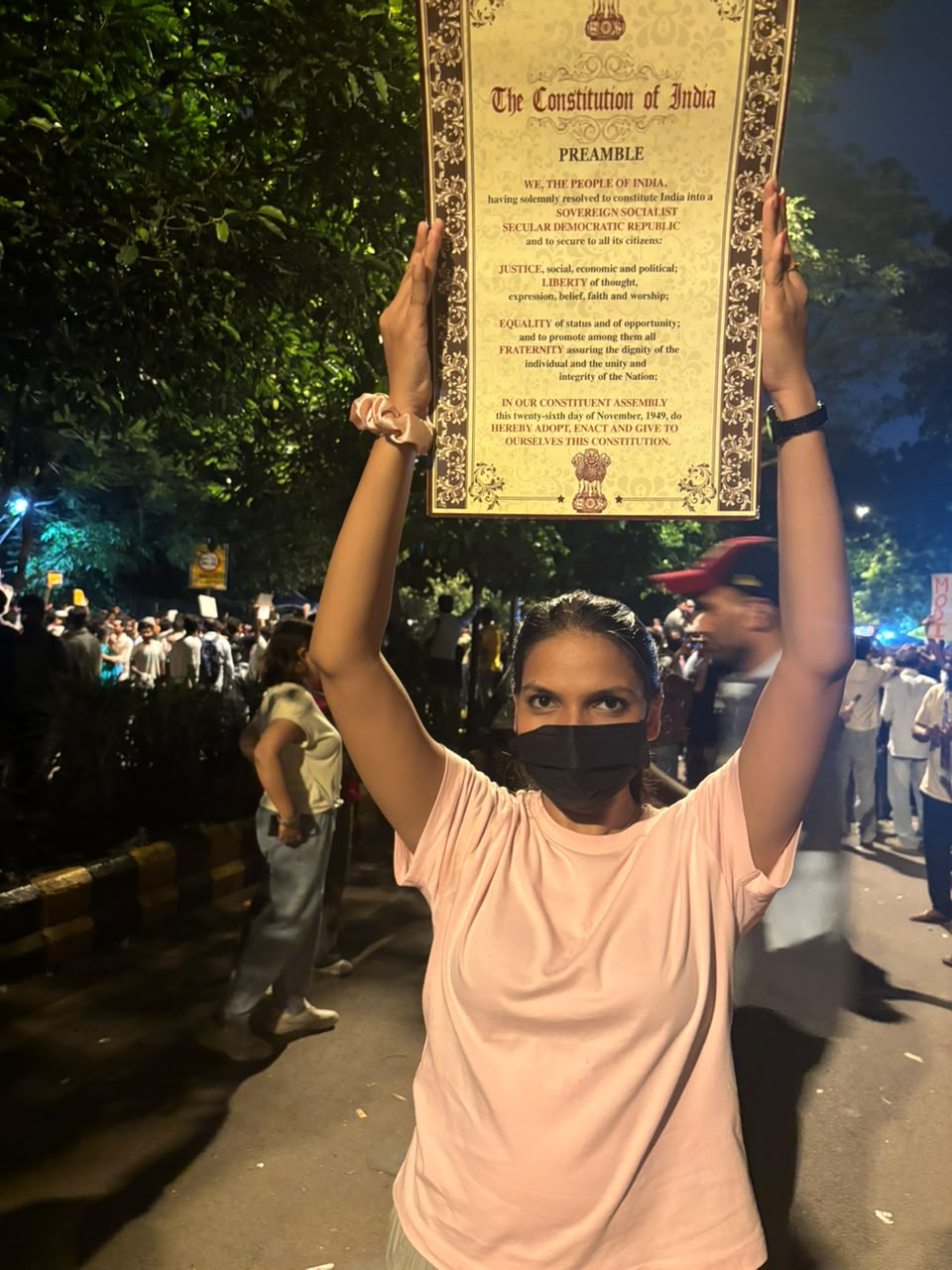 एक प्रदर्शनकारी युवती भारत का संविधान का पोस्टर लेकर आई।